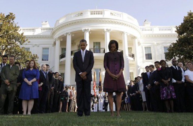 U.S. President Barack Obama and first lady Michelle Obama observe a moment of silence on the 11th anniversary of the September 11 attacks, on the South Lawn of the White House in Washington, September 11, 2012.