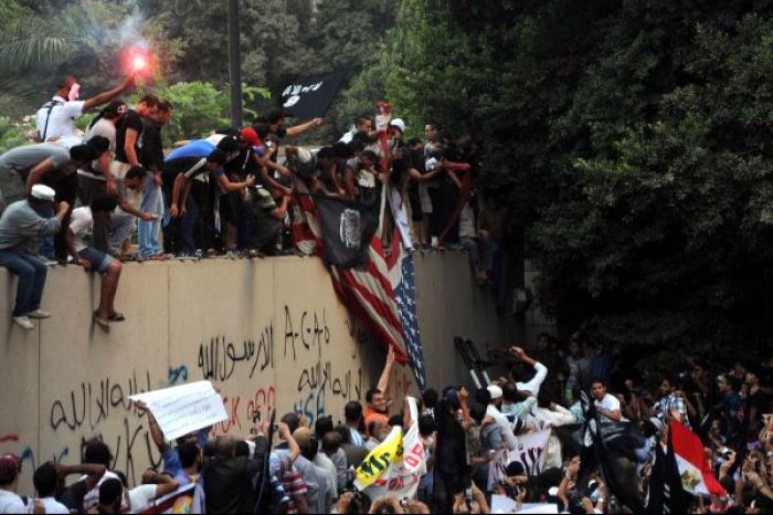 Press TV shared an image online of protesters in Egypt tearing down the U.S. flag and waiving black Islamic flags.