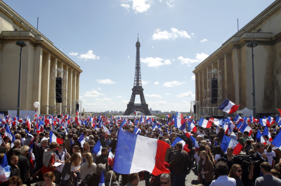 French supporters wave flags in front the Eiffel Tower in Paris May 1, 2012.