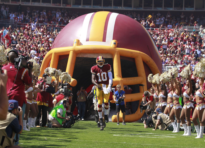 Washington Redskins quarterback Robert Griffin III runs onto the field in Landover, Maryland .
