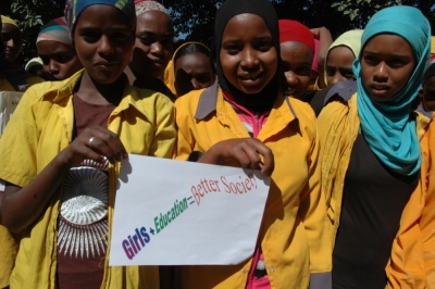 Young girls in Ethiopia participating in the 10x10 campaign hold up signs advocating education for women.