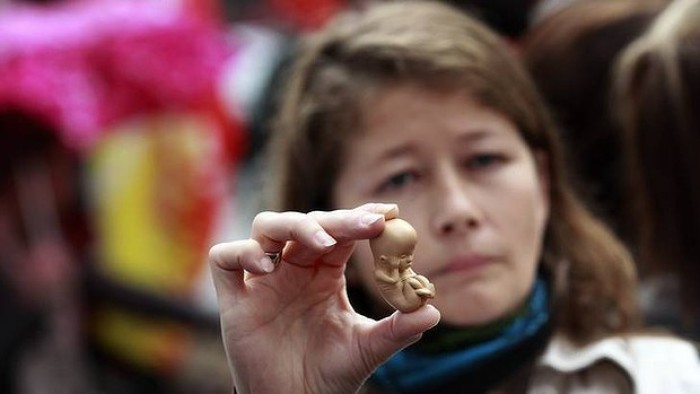 A pro-life campaigner holds up a model of a 12-week-old embryo outside the Marie Stopes clinic in Belfast, Northern Ireland, in this undated photo.