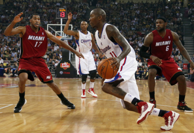 Jamal Crawford (C) of Los Angeles Clippers drives the ball between LeBron James and Garrett Temple of Miami Heat during the NBA China Games at Wukesong arena in Beijing October 11, 2012.
