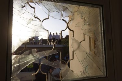 Israelis are seen through a window damaged after a rocket fired from the Gaza Strip landed in the southern town of Ofakim November 18, 2012.