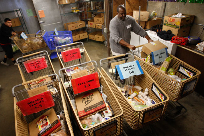 Workers fill carts with food for the poor at the Foothill Unity Center food bank in Monrovia, California, November 14, 2012. The number of people served by the Foothill Unity Center has tripled in the last four years. Groups that provide food for pantries say this is one of the toughest years yet in terms of low levels of federal government 'surplus' commodity donations, which have accounted for a major portion of meat and other proteins in the past. Those shortfalls are putting real pressure on low income families and individuals, who are more squeezed than ever because of still high unemployment, federal and state budget cuts, higher grocery costs from recent drought, rising rents and transport costs.