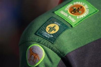 A scout wears various merit badges as he participates in a ceremony in Sydney marking the World centenary of Scouting August 1, 2007.