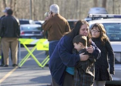A young boy is comforted outside Sandy Hook Elementary School after a shooting in Newtown, Connecticut, December 14, 2012.