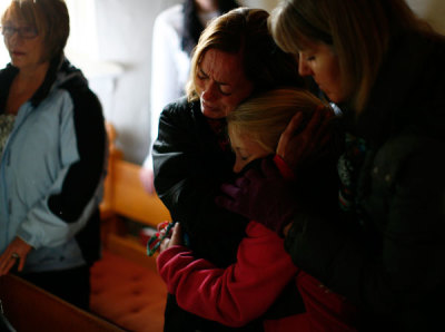 People react during a prayer service at St. John's Episcopal church near Sandy Hook Elementary School in Sandy Hook, Connecticut December 15, 2012. Residents of the small Connecticut community of Newtown were reeling on Saturday from one of the worst mass shootings in U.S. history, as police sought answers about what drove a 20-year-old gunman to slaughter 20 children at an elementary school.