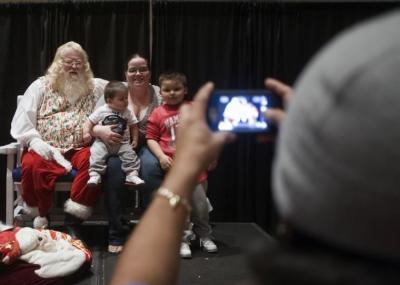 A family takes a photo with Santa at Christmas for the City in Winston-Salem, N.C., Dec. 19, 2012.