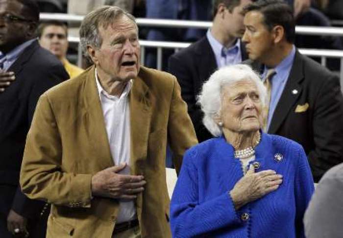 Former U.S. President George H.W. Bush and his wife, former first lady Barbara Bush, stand during the national anthem prior to the University of Connecticut versus Butler University men's final NCAA Final Four college basketball championship game in Houston, Texas, April 4, 2011.