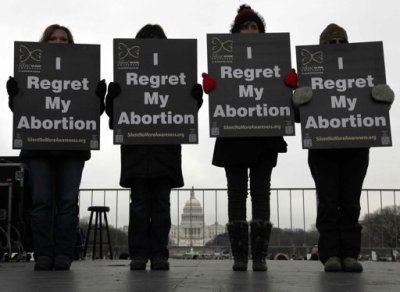 Activists hold signs reading 'I regret my abortion' onstage as they participate in the annual March for Life rally in Washington, January 25, 2013.