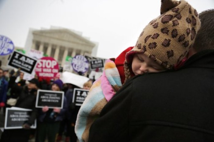 Paisley Fowles, aged one, of Naples, Florida, sleeps on her father's shoulder amidst the din of the annual March for Life rally at the U.S. Supreme Court building in Washington, January 25, 2013. The anti-abortion marchers on Friday marked the 40th anniversary of the Roe v. Wade U.S. Supreme Court ruling legalizing abortion, and Pope Benedict expressed support for the demonstrators.