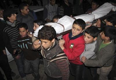Children carry the body of a friend that was killed by shelling during heavy fighting between the Free Syrian Army and the forces of Syrian President Bashar al Assad in Jobar district of Damascus January 25, 2013.