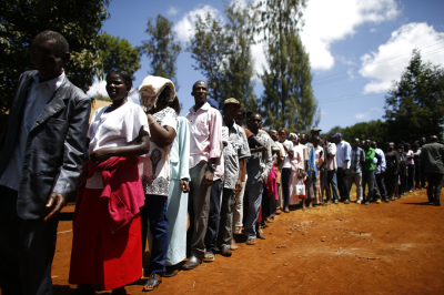 People wait in line to cast their ballots in front of a polling station in Kenya's town of Gatundu March 4, 2013. Polling stations opened up to Kenyans on Monday for a tense presidential election that will test whether the east African nation can repair its damaged reputation after the tribal blood-letting that followed a 2007 poll.
