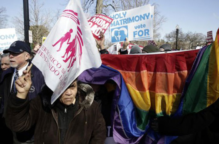 A supporters of traditional marriage passes supporters of gay marriage as the two groups demonstrate in front of the Supreme Court in Washington March 26, 2013. U.S. Supreme Court justices signaled on Tuesday that they are reluctant to embrace a broad ruling finding a fundamental right to marriage for gays and lesbians across the United States.