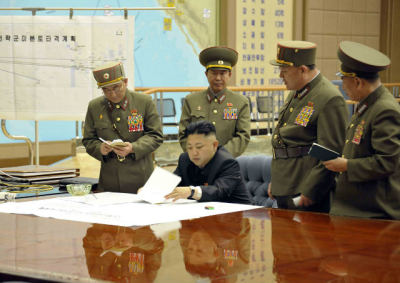 North Korean leader Kim Jong-un presides over an urgent operation meeting on the Korean People's Army Strategic Rocket Force's performance of duty for firepower strike at the Supreme Command in Pyongyang, March 29, 2013. The sign on the left reads, 'Strategic force's plan to hit the mainland of the U.S.'