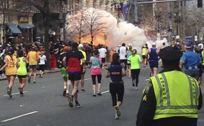 Runners continue to run towards the finish line of the Boston Marathon as an explosion erupts near the finish line of the race in this photo exclusively licensed to Reuters by photographer Dan Lampariello after he took the photo in Boston, Massachusetts, April 15, 2013. Two simultaneous explosions ripped through the crowd at the finish line of the Boston Marathon on Monday, killing at least two people and injuring dozens on a day when tens of thousands of people pack the streets to watch the world famous race.