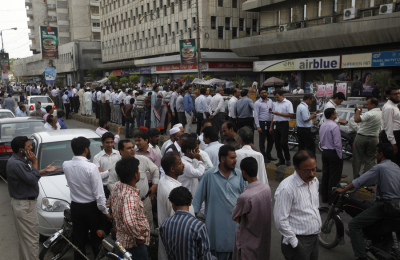 People stand outside of their office buildings following an earthquake tremor in Karachi April 16, 2013. An 8.0 magnitude earthquake struck Iran on Tuesday with tremors felt across Pakistan among other regions, media reported.