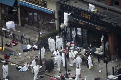 This photo shows authorities working in the aftermath of the Boston bombings that took place Monday April 15, 2013. This photo was taken from exactly the same angle as the camera from Lord and Taylor which is believed to have shown someone walking towards the mail box before dropping a package and walking away.