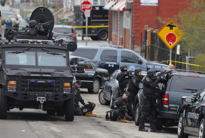 Police officers take position during a search for the Boston Marathon bombing suspects in Watertown, Massachusetts April 19, 2013. Police on Friday killed one suspect in the Boston Marathon bombing during a shootout and mounted a house-to-house search for a second man in the suburb of Watertown after a bloody night of shooting and explosions in the city's streets.