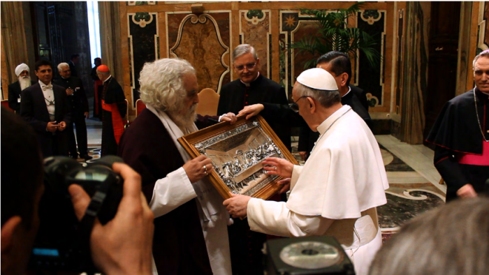Armondo Linus Acosta, filmmaker, presents Pope Francis with a silver bas-relief of The Last Supper.
