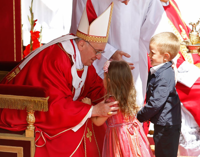 Pope Francis embraces a child as he leads a mass in Saint Peter's Square at the Vatican May 19, 2013.
