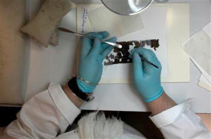 A preservationist works on a fragment of the Dead Sea Scrolls in a laboratory in the Israel Museum in Jerusalem October 18, 2010.