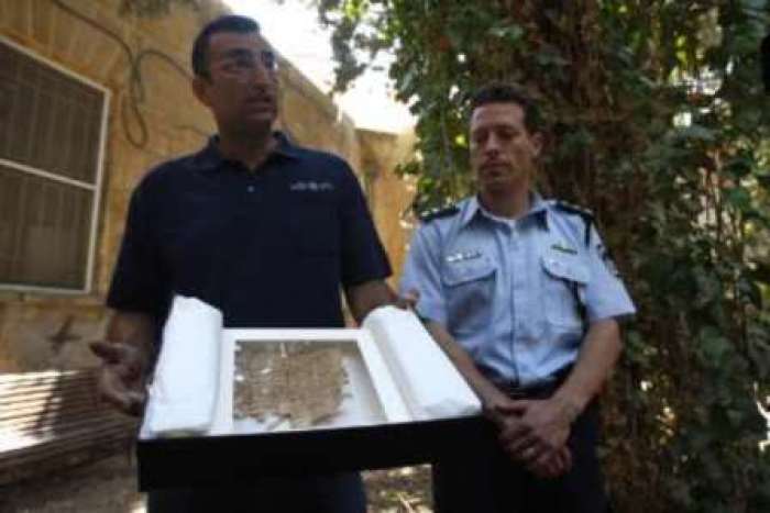 Israeli police spokesperson Micky Rosenfeld (R) and Amir Ganor, director of the unit for the prevention of antiquities robbery in the Israeli Antiquities Authority, show a document, thought to be an ancient text written on papyrus, at Jerusalem Magistrates Court May 6, 2009. 