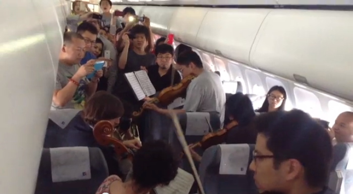 The Philadelphia Orchestra perform for passengers stuck on a flight delayed on the tarmac in Beijing, China for three hours on June 7, 2013.