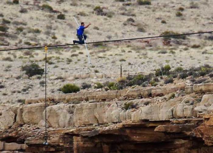 Daredevil Nik Wallenda gives a thumbs-up sign as he nears the end, after walking on a two-inch (5-cm) diameter steel cable rigged 1,400 feet (426.7 metres) across more than a quarter-mile deep remote section of the Grand Canyon near Little Colorado River, Arizona June 23, 2013.