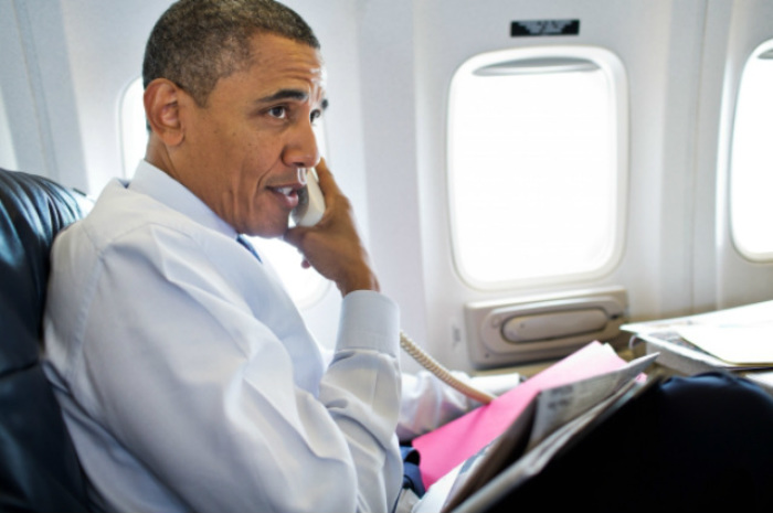 In this August 1, 2012, file photo, President Barack Obama is seen talking on the phone with members of the U.S. Olympic women's gymnastics team during a phone call from Air Force One.