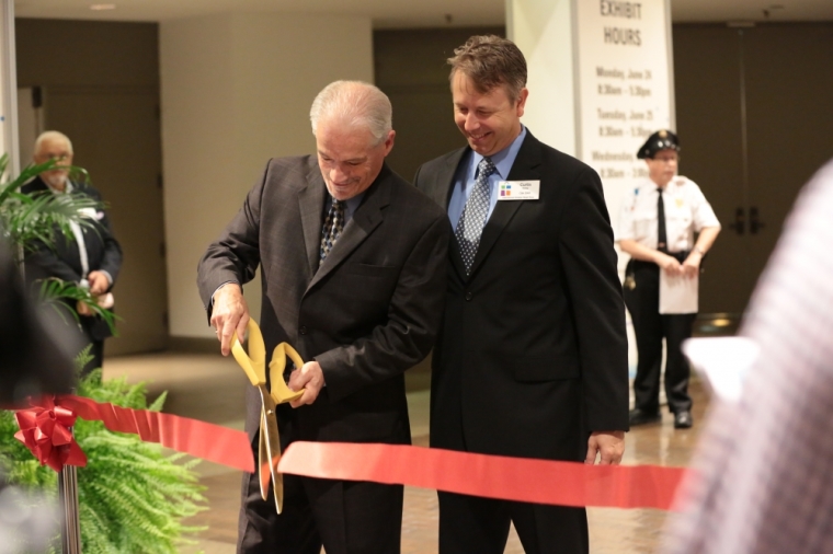 George Thomsen, chairman of the CBA board (l) cuts the ribbon signalling the official opening of the International Christian Retail Show at the America's Convention Center in St. Louis, Mo. on Monday June 24, 2013 while Curtis Riskey, executive director of the CBA looks on.