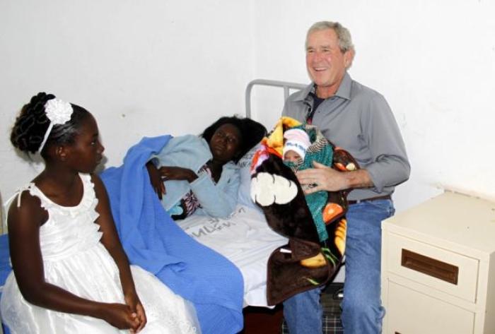 Former President George W. Bush holds a baby named after him at Ngungu Cancer Clinic in Zambia's Central Province town of Kabwe July 3, 2012. He painted another clinic on Monday.