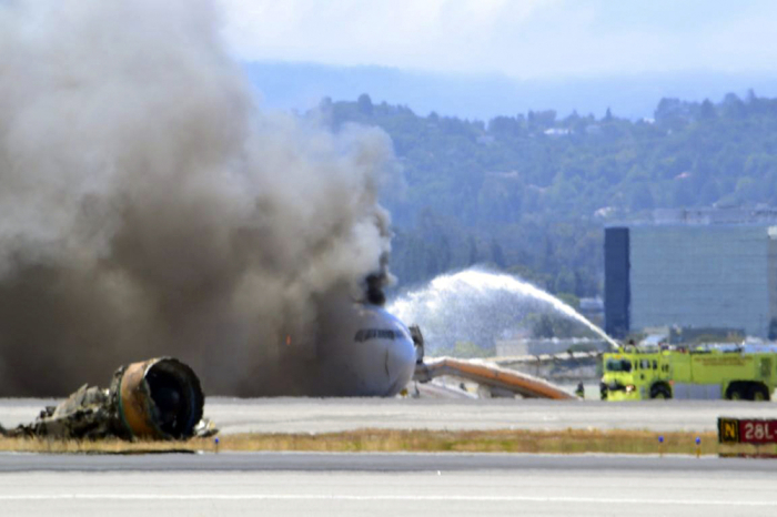 Firefighters spray water on Asiana Airlines flight 214 as it sits on the runway burning at San Francisco Airport International Airport in this July 6, 2013 handout. The plane, with 307 people on board, crashed and burst into flames as it landed at San Francisco International Airport on Saturday after a flight from Seoul, and initial reports said two people were killed and more than 100 sent to hospitals.