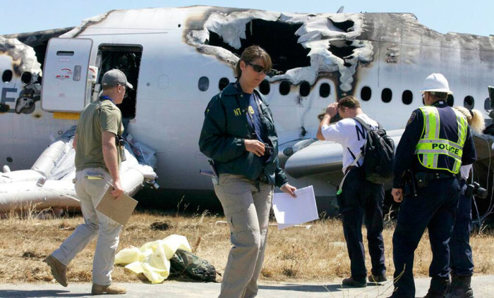 U.S. National Transportation Safety Board (NTSB) investigators stand at the scene of the Asiana Airlines Flight 214 crash site at San Francisco International Airport in San Francisco, California in this handout photo released on July 7, 2013. The crew of the Asiana Airlines plane that crashed Saturday at San Francisco airport tried to increase its speed and abort its landing just seconds before it hit the seawall in front of the airport runway, according to flight recorders recovered by the National Transportation Safety Board.