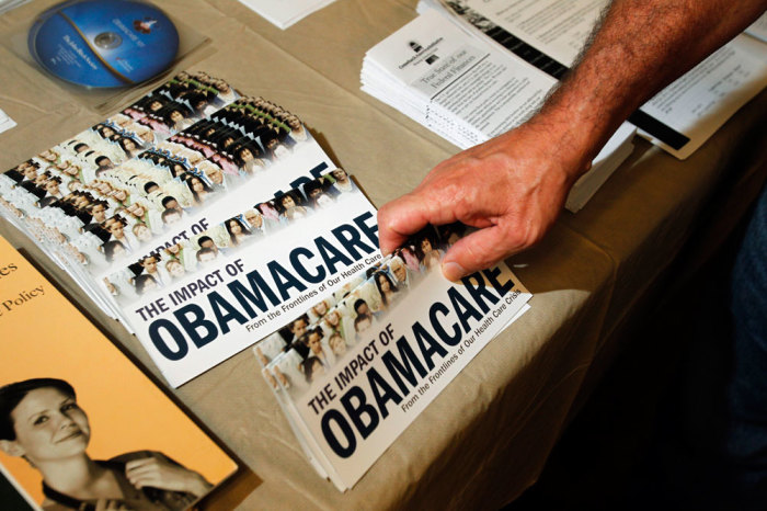 A Tea Party member reaches for a pamphlet titled 'The Impact of Obamacare', at a 'Food for Free Minds Tea Party Rally' in Littleton, New Hampshire October 27, 2012.