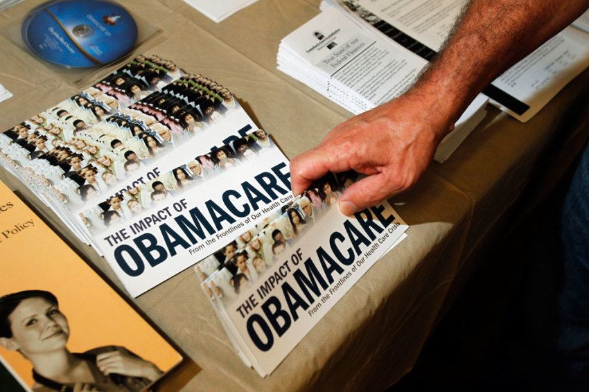 A Tea Party member reaches for a pamphlet titled "The Impact of Obamacare", at a "Food for Free Minds Tea Party Rally" in Littleton, New Hampshire October 27, 2012.