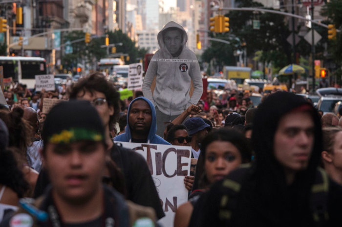 An image of Trayvon Martin (C) is carried amidst hundreds of demonstrators who are demanding justice while marching to Times Square from New York's Union Square July 14, 2013. U.S. President Barack Obama called for calm on Sunday after the acquittal of George Zimmerman in the shooting death of unarmed black teenager Trayvon Martin, as thousands of civil rights demonstrators turned out at rallies to condemn racial profiling. Zimmerman, cleared late on Saturday by a Florida jury of six women, still faces public outrage, a possible civil suit and demands for a federal investigation.