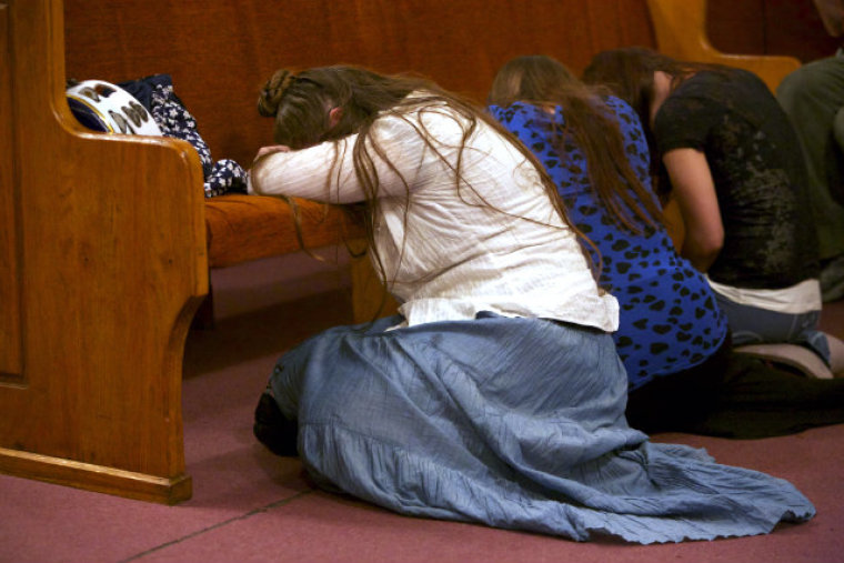 Women kneel at pews during a service at Pastor Andrew Hamblin's Tabernacle Church of God in LaFollette, Tenn.