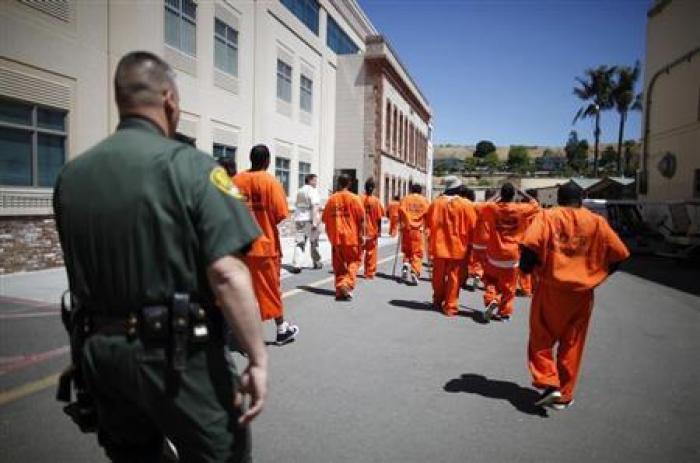 Inmates are escorted by a guard through San Quentin state prison in San Quentin, California, June 8, 2012.