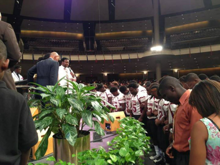 Bishop Eddie Long's New Birth Missionary Baptist Church publicly shared this photo on Facebook Sunday of members of the Towers High School football team, the Titans, responding to an altar call to become Christians.