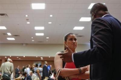 A woman stands with her paperwork as she speaks with a recruiter while attending a job fair in New York. June 11, 2013.