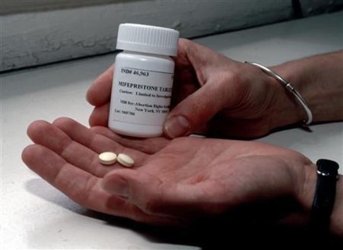 A bottle and two pills of mifepristone, formerly known as RU-486, are seen in a handout photo.