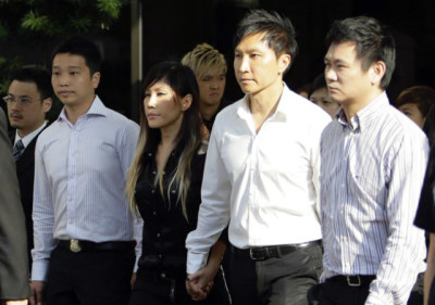 City Harvest Church founder Kong Hee (2nd R) holds the hand of his wife Sun Ho, also known as Ho Yeow Sun, as he exits the Subordinate Courts in Singapore on June 27, 2012. Kong Hee, the founder of City Harvest Church, one of Singapore's largest churches, is accused of misusing at least S$23 million ($18 million) of church funds to support his wife's singing career, the Singapore Commissioner of Charities said.