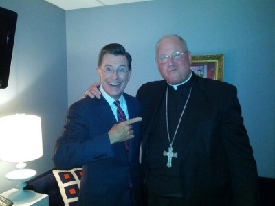 Stephen Colbert (L) and Cardinal Timothy Dolan (R) posing for a photo in the 'green room' before Dolan's appearance on the The Colbert Report on Sept. 3, 2013.