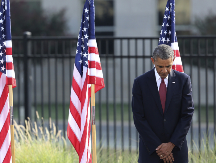 U.S. President Barack Obama bows his head during a prayer at remembrance ceremonies for 9/11 victims at the Pentagon 9/11 Memorial in Washington September 11, 2013.