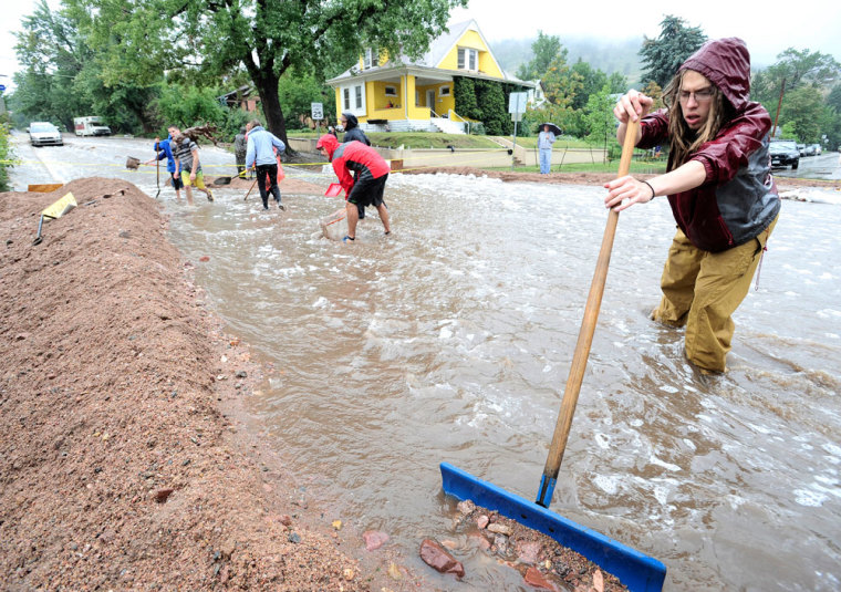 Nick Carter shovels debris into a dike as heavy rains cause severe flooding in Boulder, Colorado September 12, 2013.