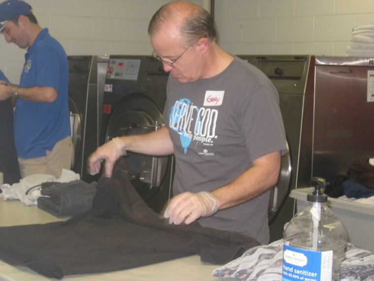 Lakewood Church mission volunteers fold clothes that have been washed and dried for members of Houston's homeless population at The Beacon in downtown Houston, Texas, Sept. 21, 2013.