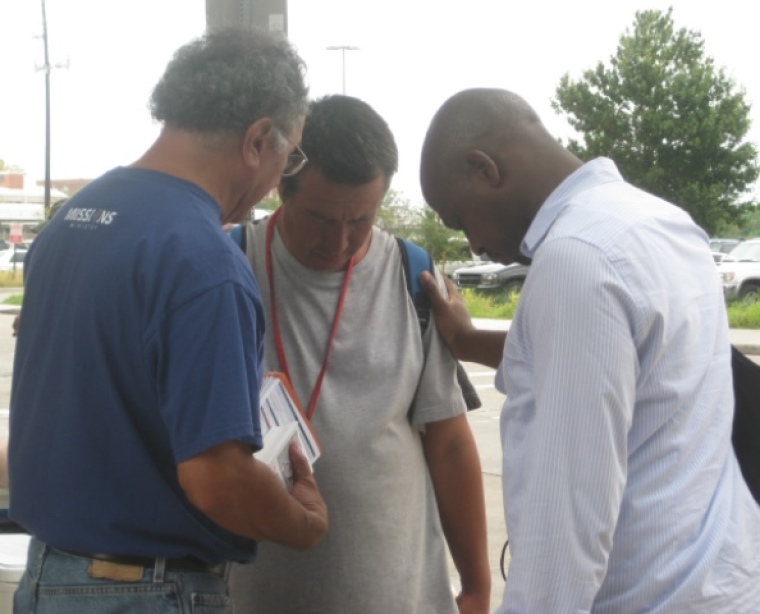 Lakewood Church street evangelism team leader Marcel Aguilar and Akin Aruwajaye pray for a man in downtown Houston, Texas, on Sept. 21, 2013.