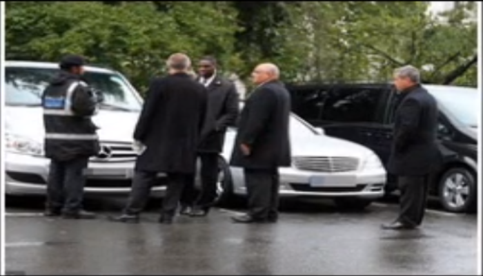 Secret Service agents confront a traffic warden (l) for ticketing a Mercedes being use to transport former U.S. Secretary of State Hillary Clinton in London on Saturday.